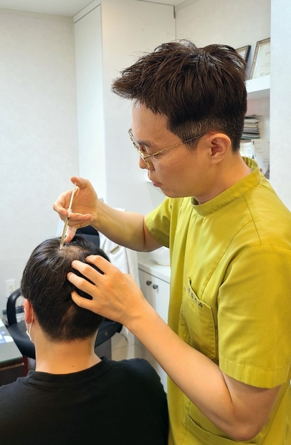 청주 탈모클리닉 미앤모 김인수 원장이 병원을 찾은 환자에게 탈모치료주사를 놓고 있다. 사진=굿모닝충청 김수미 기자