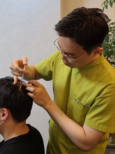 청주 탈모클리닉 미앤모 김인수 원장이 환자의 탈모 진행 부위에 주사 치료를 하고 있다. 사진=굿모닝충청 김수미 기자