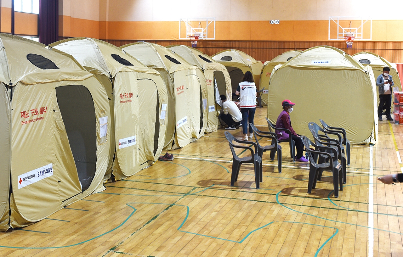 대피소에서 주민 한명이 텐트에서 나와 재난 TV방송을 보고 있다.(사진=채원상 기자)