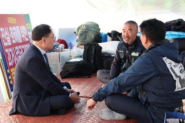 더불어민주당 이광희 의원이 30일 오전 국회 앞에서 단식농성 중인 장옥기 건설노조위원장과 이야기를 나누고 있다. (사진=의원실)