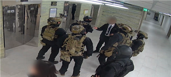 지난해 12월 4일 새벽 국회 지하 1층에 진입한 707특임단 모습. 김현태 특임단장(검정색 단복을 입은 군인)이 국회 직원으로부터 계엄 해제가 의결됐다는 설명을 듣고 상부 지시를 확인하려고 전화 통화를 시도하고 있다. (사진=국회 폐쇄회로티비, 더불어민주당 윤석열 내란국정조사특별위원회 제공)