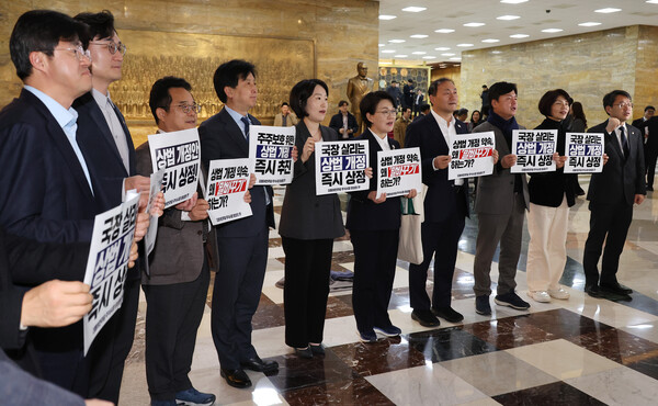 더불어민주당 의원들이 27일 오후 국회 본회의장 앞에서 '상법 개정안' 통과를 촉구하는 손팻말을 들고 있다. (사진=연합뉴스) 