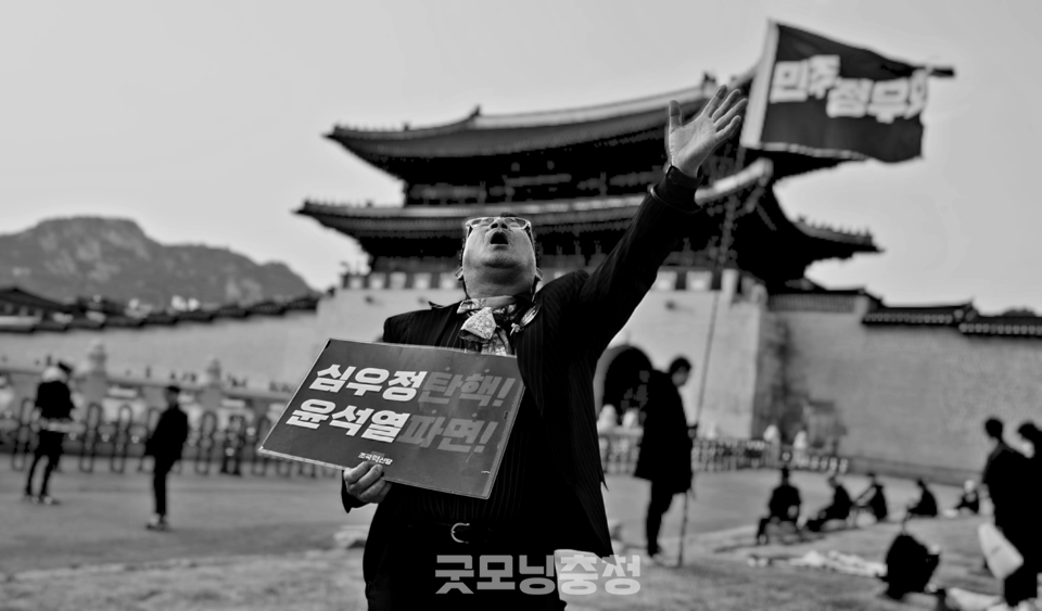 15일 오후 서울 광화문 앞에서 한 시민이 '심우정 탄핵, 윤석열 파면'이라는 문구가 적힌 피켓을 들고 구호를 외치고 있다. 시민은 '임을 위한 행진곡'을 열창했다. (포토샵 흑백 변환. 사진=굿모닝충청 설인호 기자) 