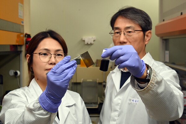 ETRI 연구진이 그래핀을 활용해 개발한 광경화 투명필름과 그래핀 광경화 콜로이드 조성물을 들어보이고 있다. 사진=ETRI 제공/굿모닝충청 김훈탁 기자