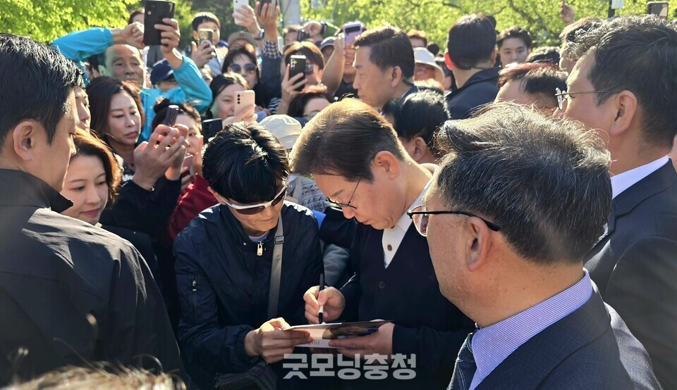 더불어민주당 이재명 대선 후보가 지난 4일 충북 제천 의림지를 방문, 지지자가 내민 자신의 책에 사인을 하고 있다. (사진=굿모닝충청 설인호 기자)_ 