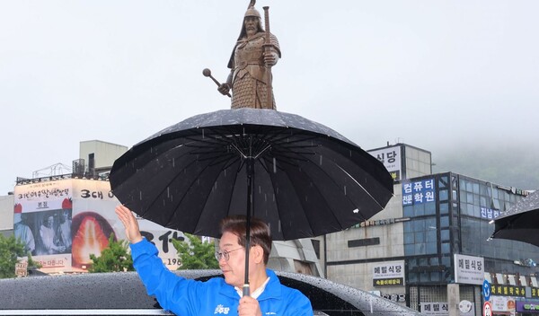 더불어민주당 이재명 대선 후보가 15일 전남 여수시 이순신광장에서 차량에 내린 후 우산을 쓰고 시민들의 환호에 답하고 있다. (사진=연합뉴스/공동취재단)