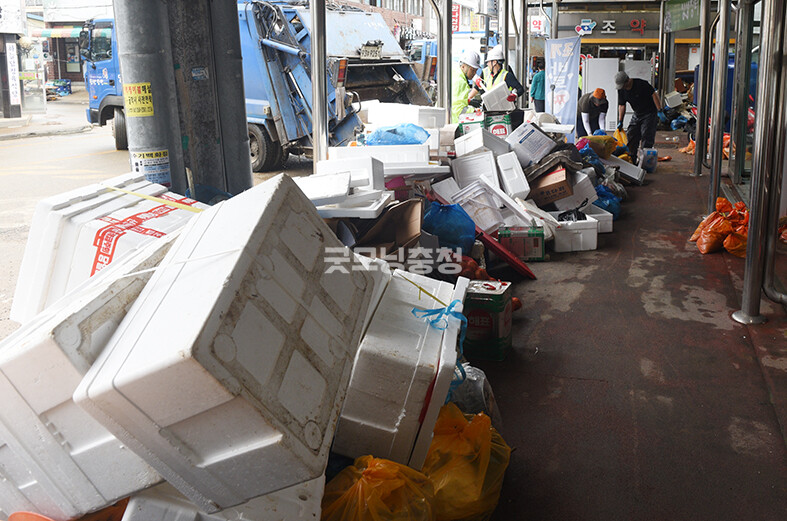 당진전통시장에서 자원봉사자들이 쓰레기와 물에 젖은 어시장 물품을 치우고 있다​(사진=채원상 기자)