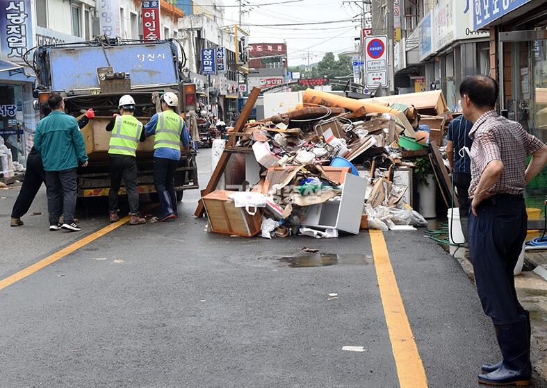 ​당진전통시장에서 자원봉사자들이 물에 젖은 물품을 치우고 있다(사진=채원상 기자)