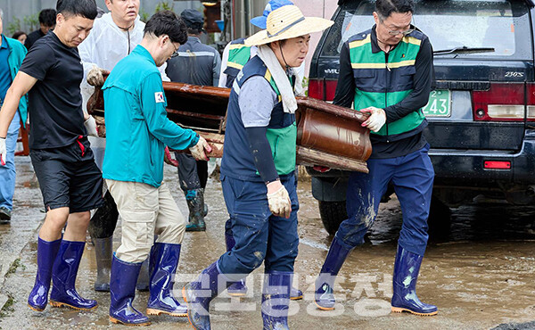 오세현 시장은 현장에서 옷에 진흙이 묻은 상태로 직원들과 쉴 틈 없이 젖은 집기를 나르고 있다. (사진=오세현 시장 페이스북/굿모닝충청=이종현 기자)