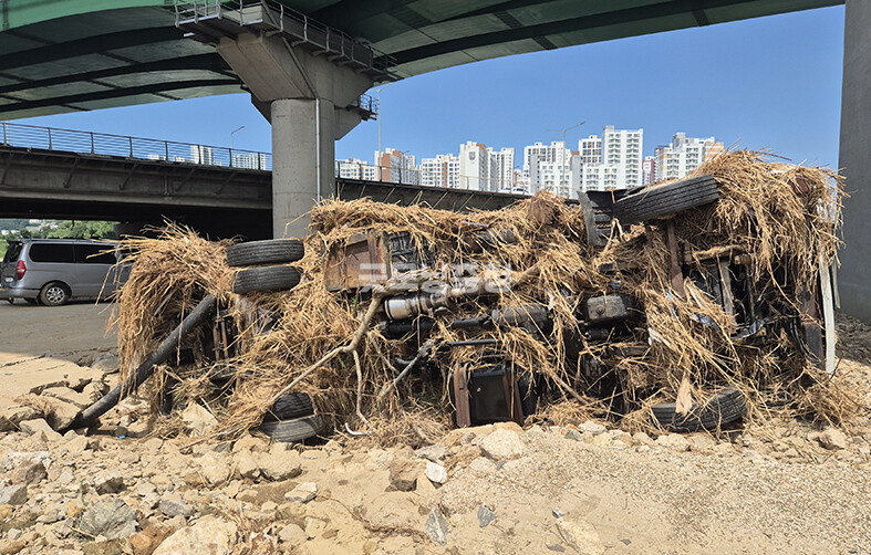배방읍 곡교천 교각밑에 침수차량이 풀에 둘러쌓여 있다(사진=채원상 기자)